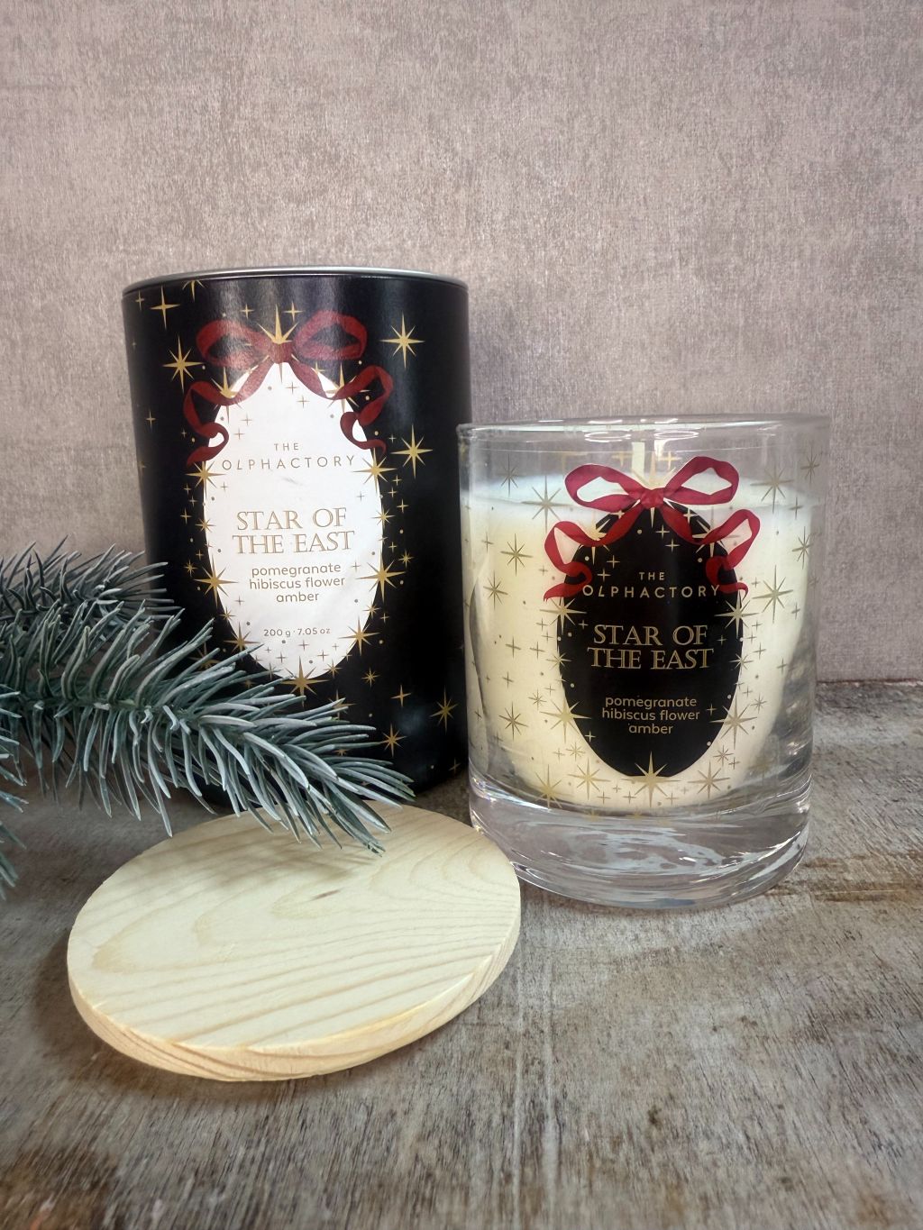 Geurkaars The Olphactory Star of the East met etiket “pomegranate • hibiscus flower • amber” in luxe zwarte verpakking met gouden sterren.