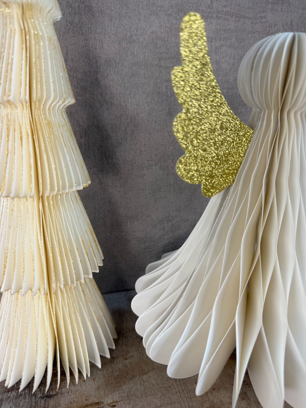 Set van een papieren kerstboom en een engel met gouden glittervleugels, samen als feestelijke kerstbundel.