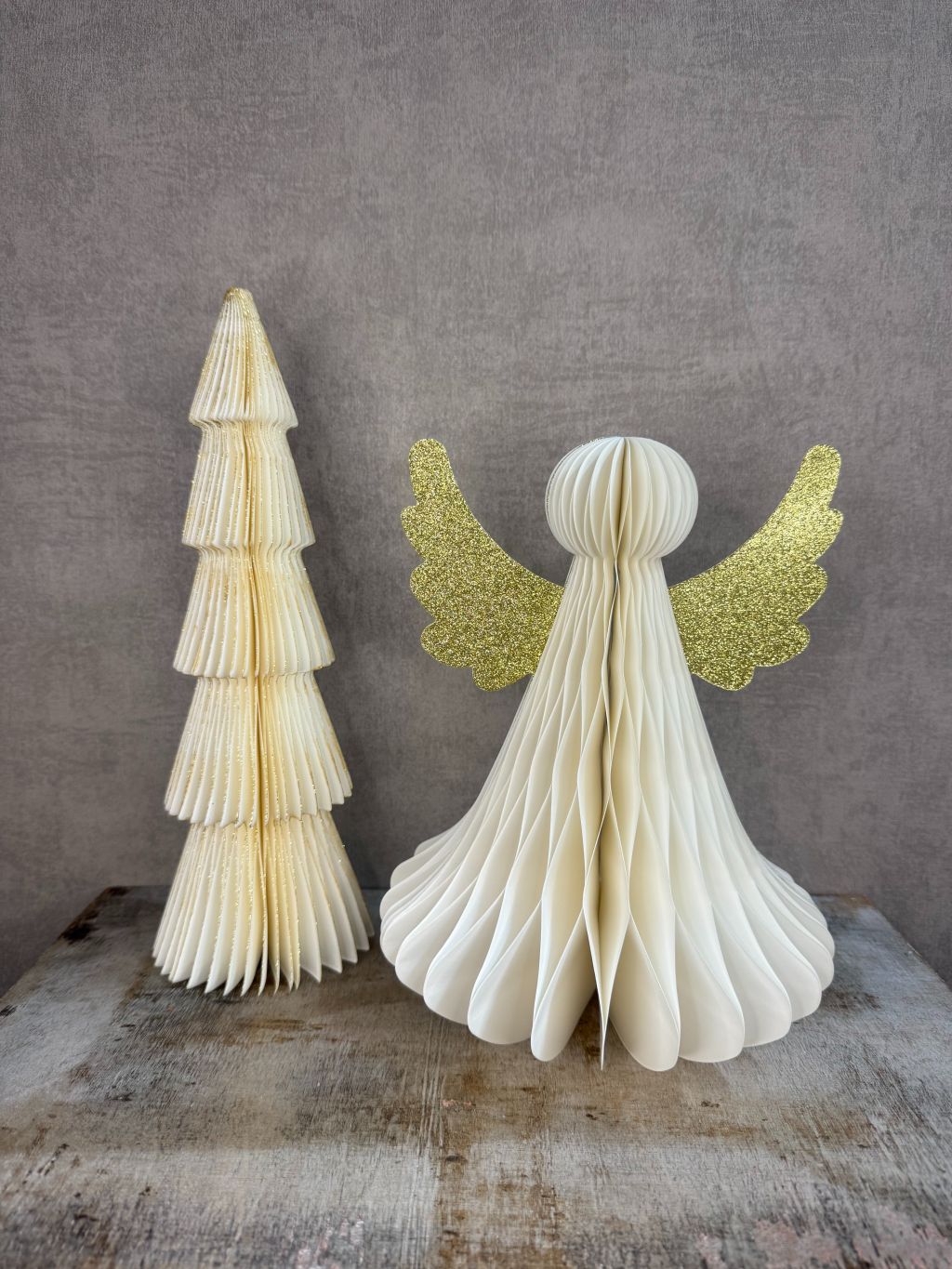 Set van een papieren kerstboom en een engel met gouden glittervleugels, samen als feestelijke kerstbundel.