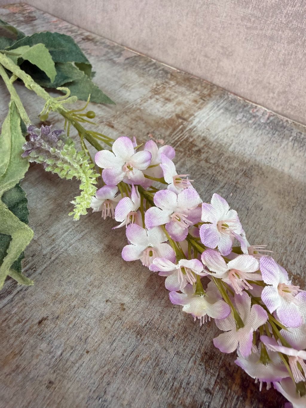 Kunstbloem Veronica in lila met slanke bloeiaar en groene bladeren tegen een neutrale achtergrond.
