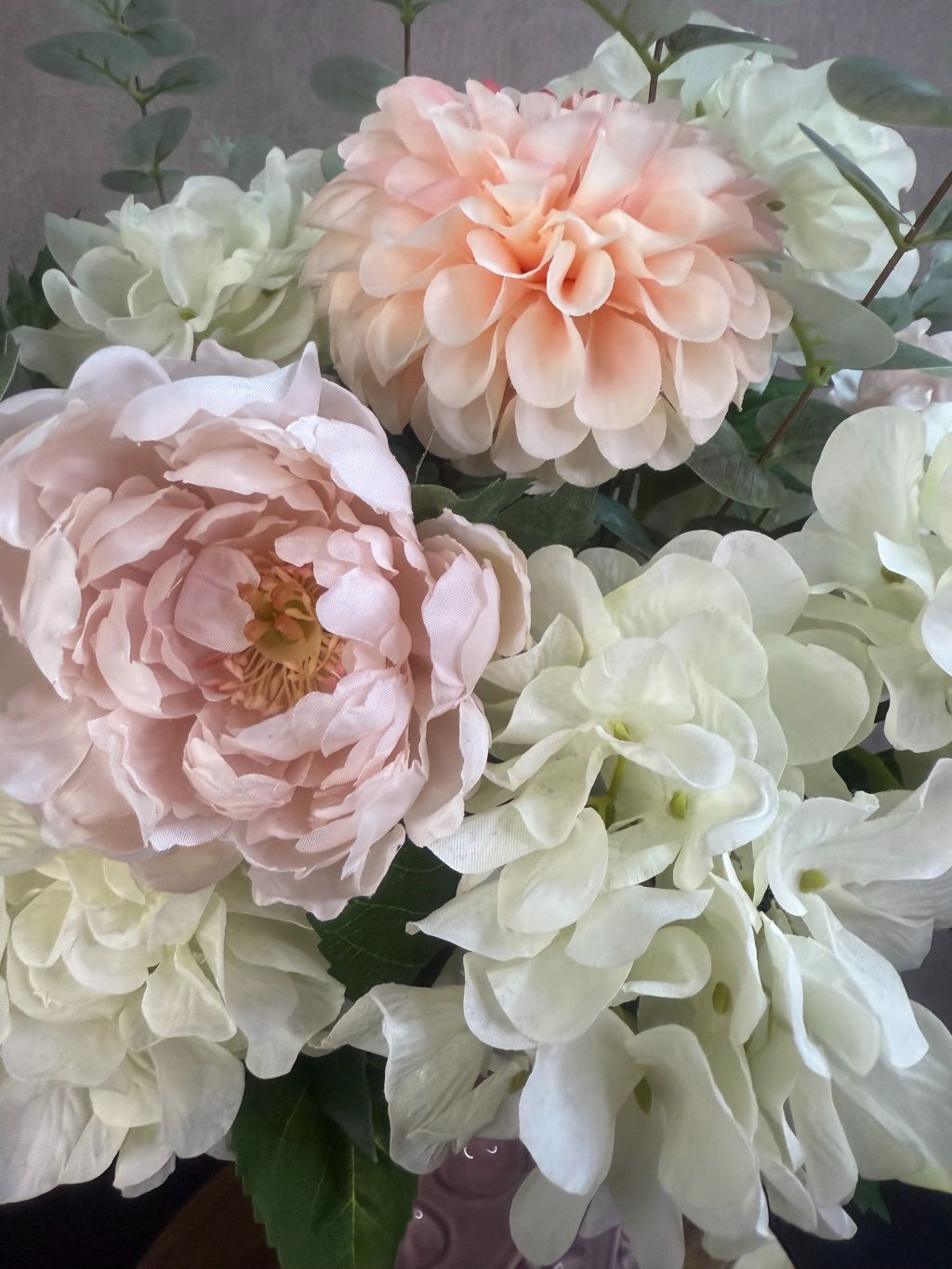 Kunstboeket Amélie – zachte bloemen in ecru, roze en zalmtinten met eucalyptus, in roze vaas met kersenmotief.