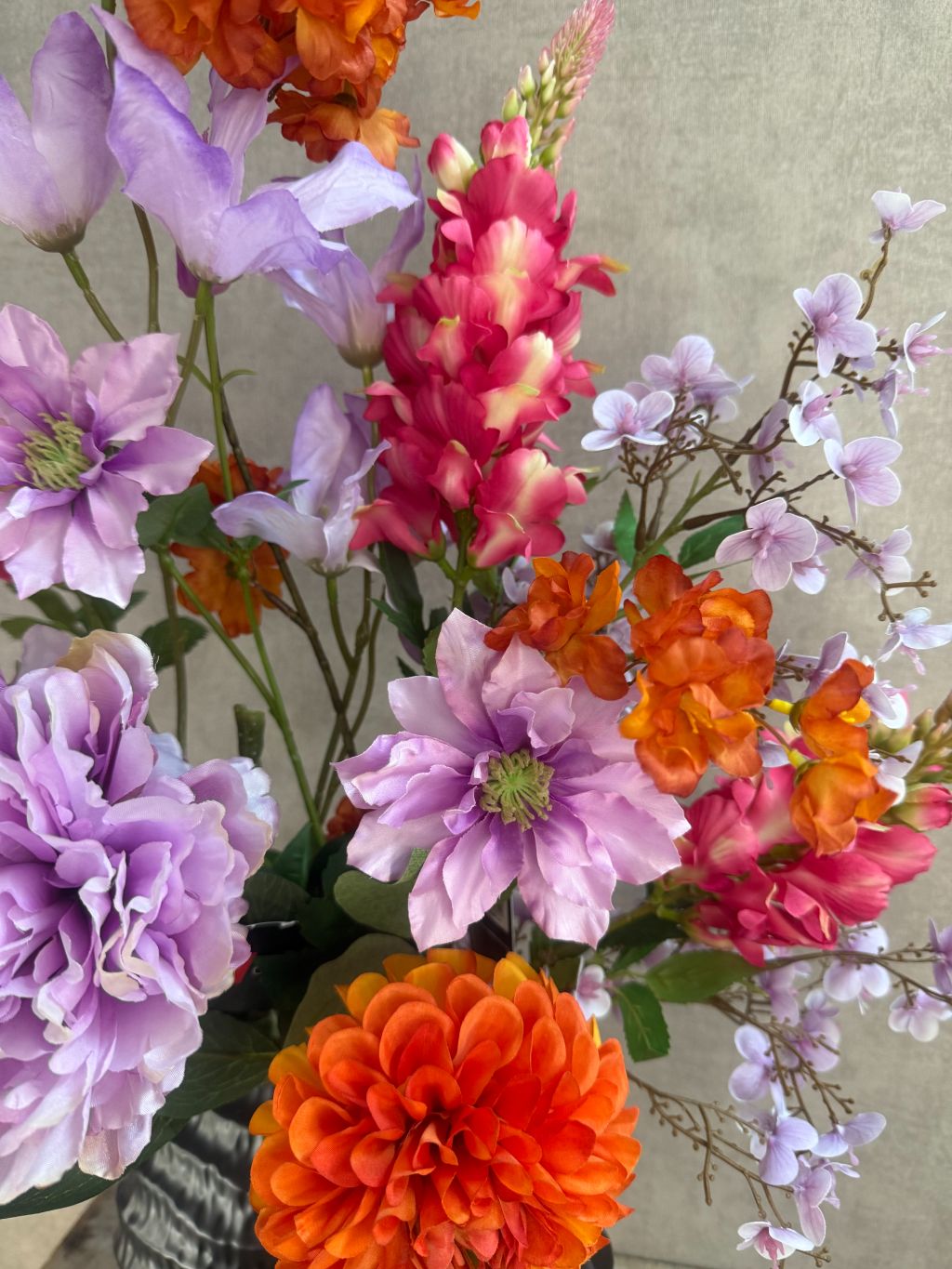 Kunstboeket met paarse, roze en oranje bloemen, front-facing geschikt voor vensterbank of wandmeubel.
