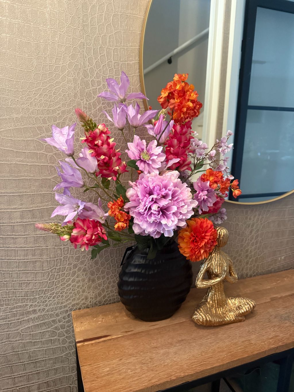 Kunstboeket La fleur op dressoir in zwarte vaas met gouden yoga beeld.