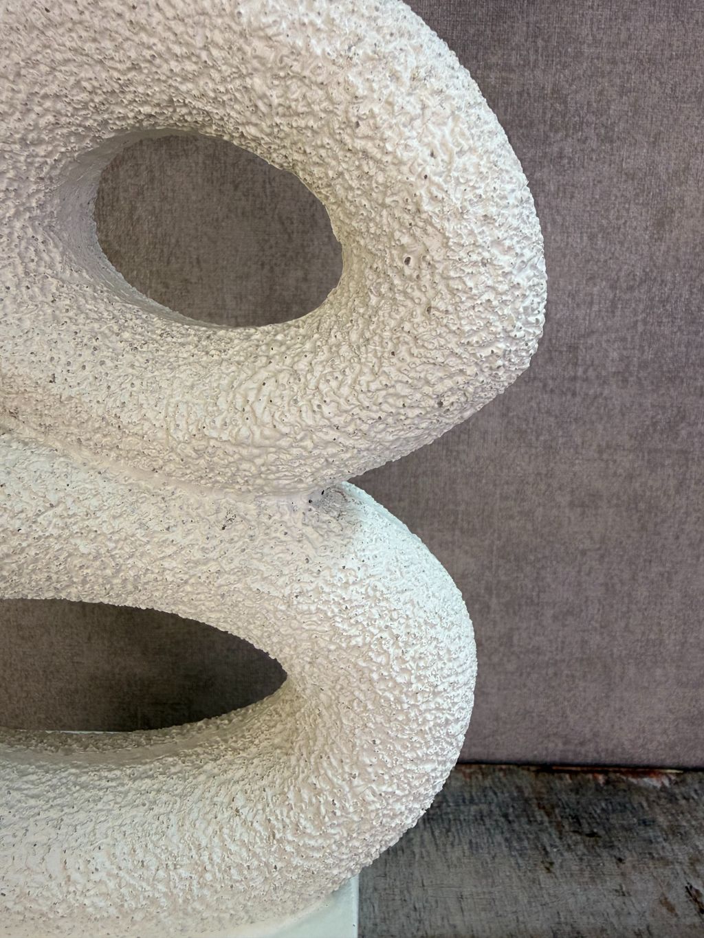 Beige abstract ornament met organische vormen op een rechthoekige voet.