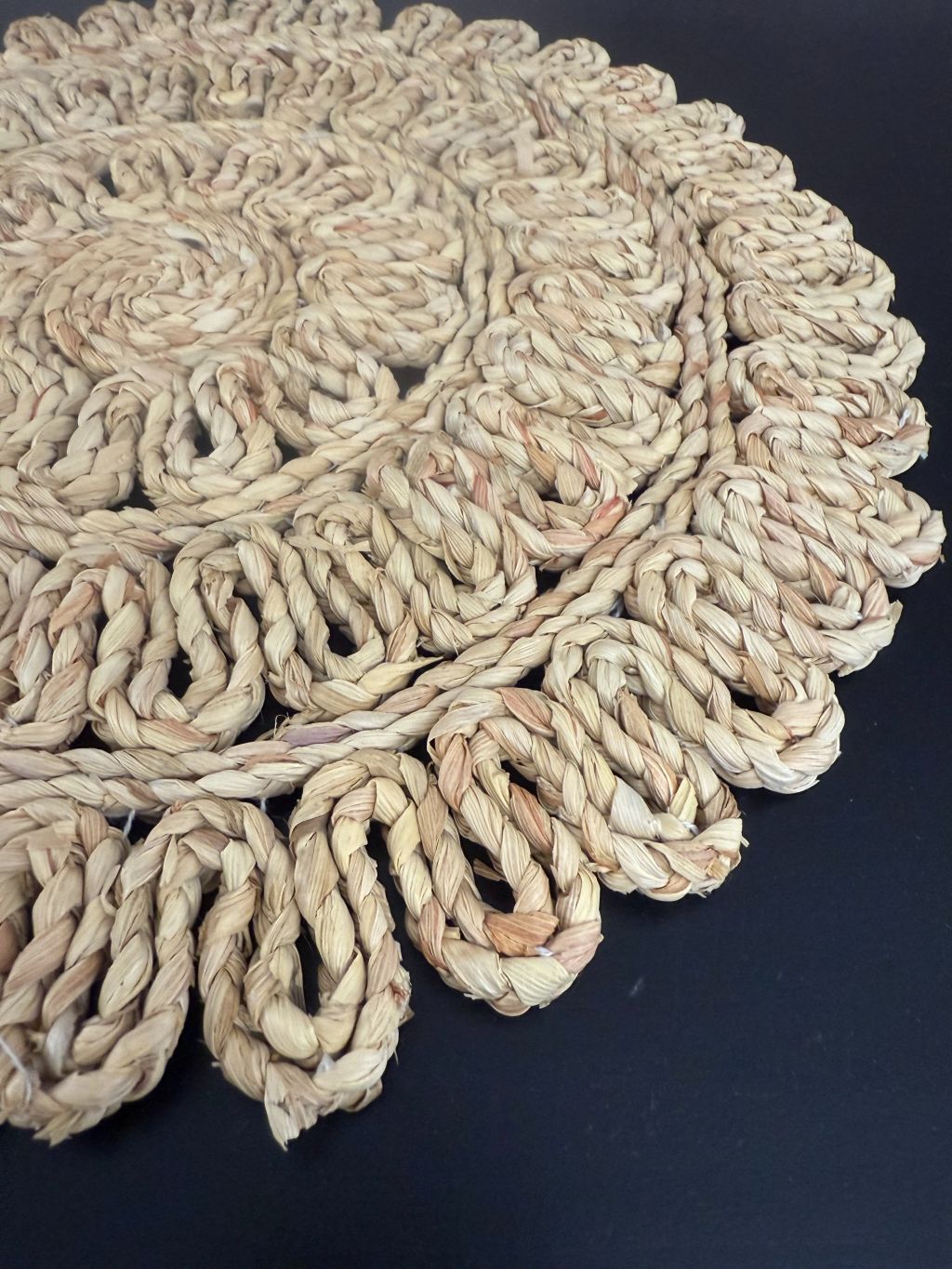 Ronde handgemaakte placemat van gevlochten raffia met lusrand in naturel kleur, merk J-line.