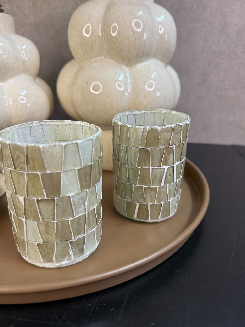 Tafel decoratie set met bruin dienblad, crème vazen, roze bloesemtakken, waxinelichthouders en amberblokje.