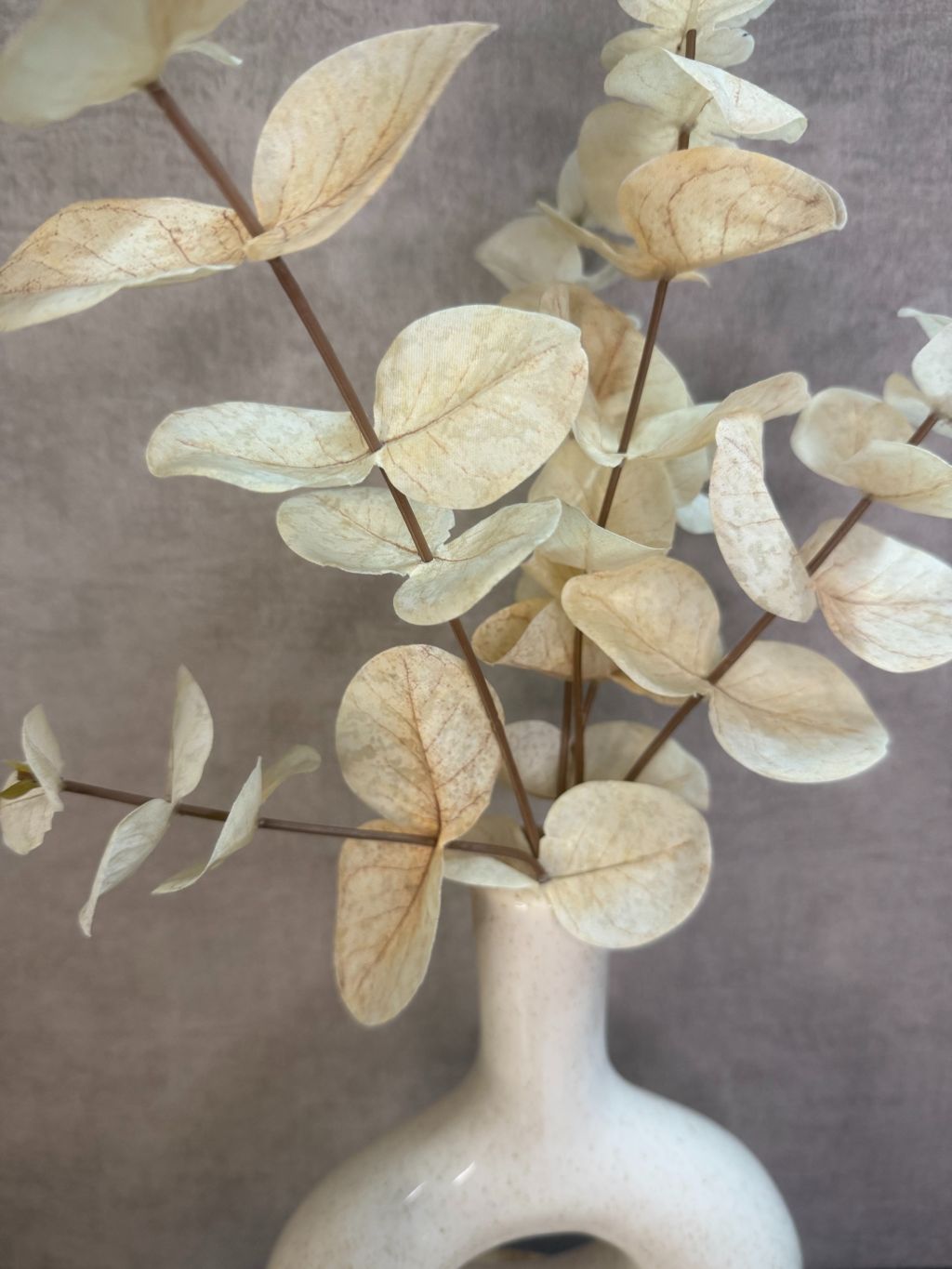 Tafel decoratie set Cosy – houten dienblad met twee beige vazen, eucalyptus tak en witte geurkaars tegen een grijze achtergrond.