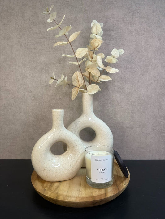 Tafel decoratie set Cosy – houten dienblad met twee beige vazen, eucalyptus tak en witte geurkaars tegen een grijze achtergrond.