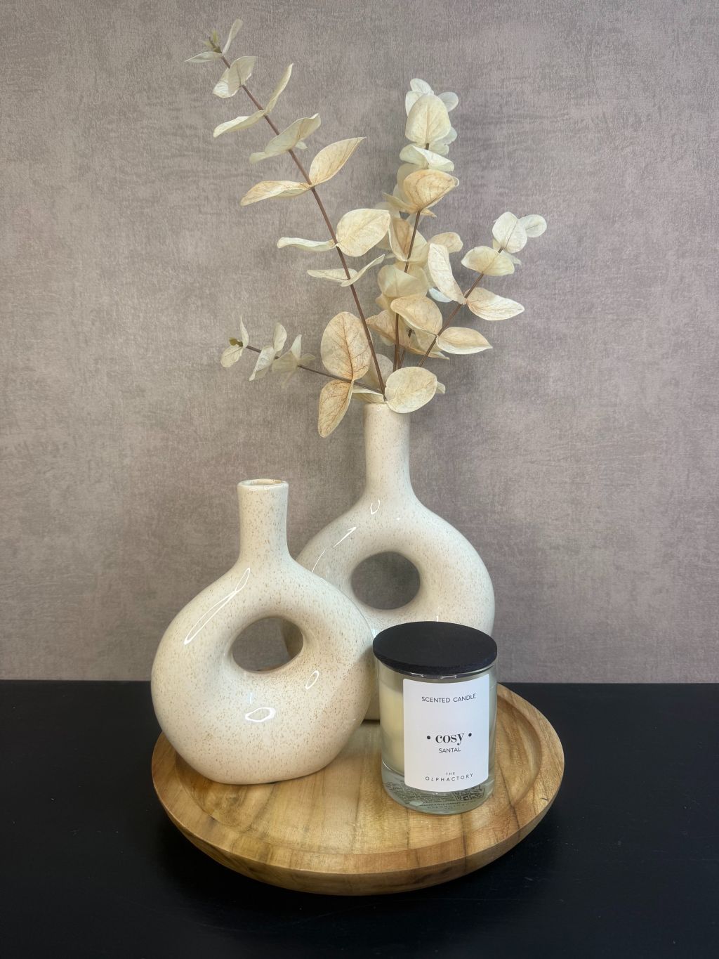 Tafel decoratie set Cosy – houten dienblad met twee beige vazen, eucalyptus tak en witte geurkaars tegen een grijze achtergrond.