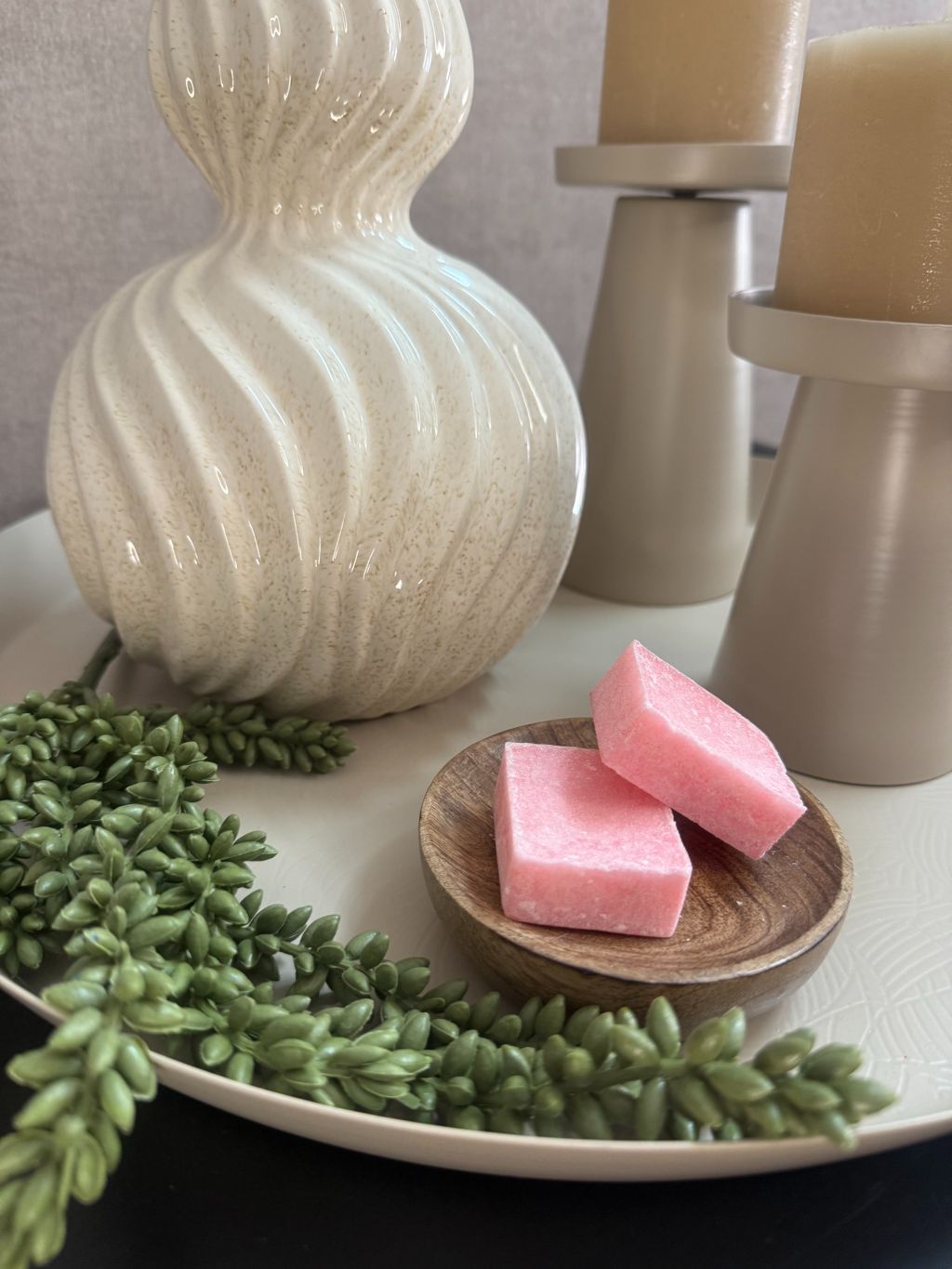 Decoratieset op beige dienblad met golvende vaas, kunsttakken, LED-kaarsen en amberblokjes in een houten schaaltje.