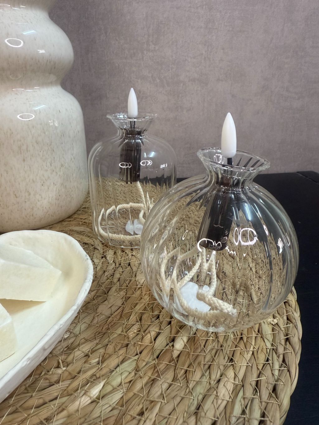 Tafel decoratie set Lovi – beige vazen met eucalyptustakken, LED-oliekaarsjes en amberblokjes op gevlochten placemat.