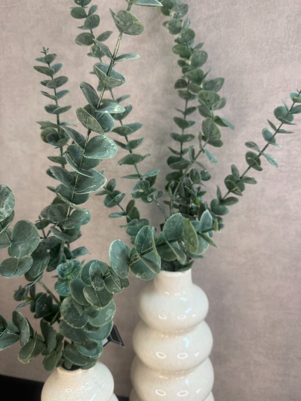 Tafel decoratie set Lovi – beige vazen met eucalyptustakken, LED-oliekaarsjes en amberblokjes op gevlochten placemat.