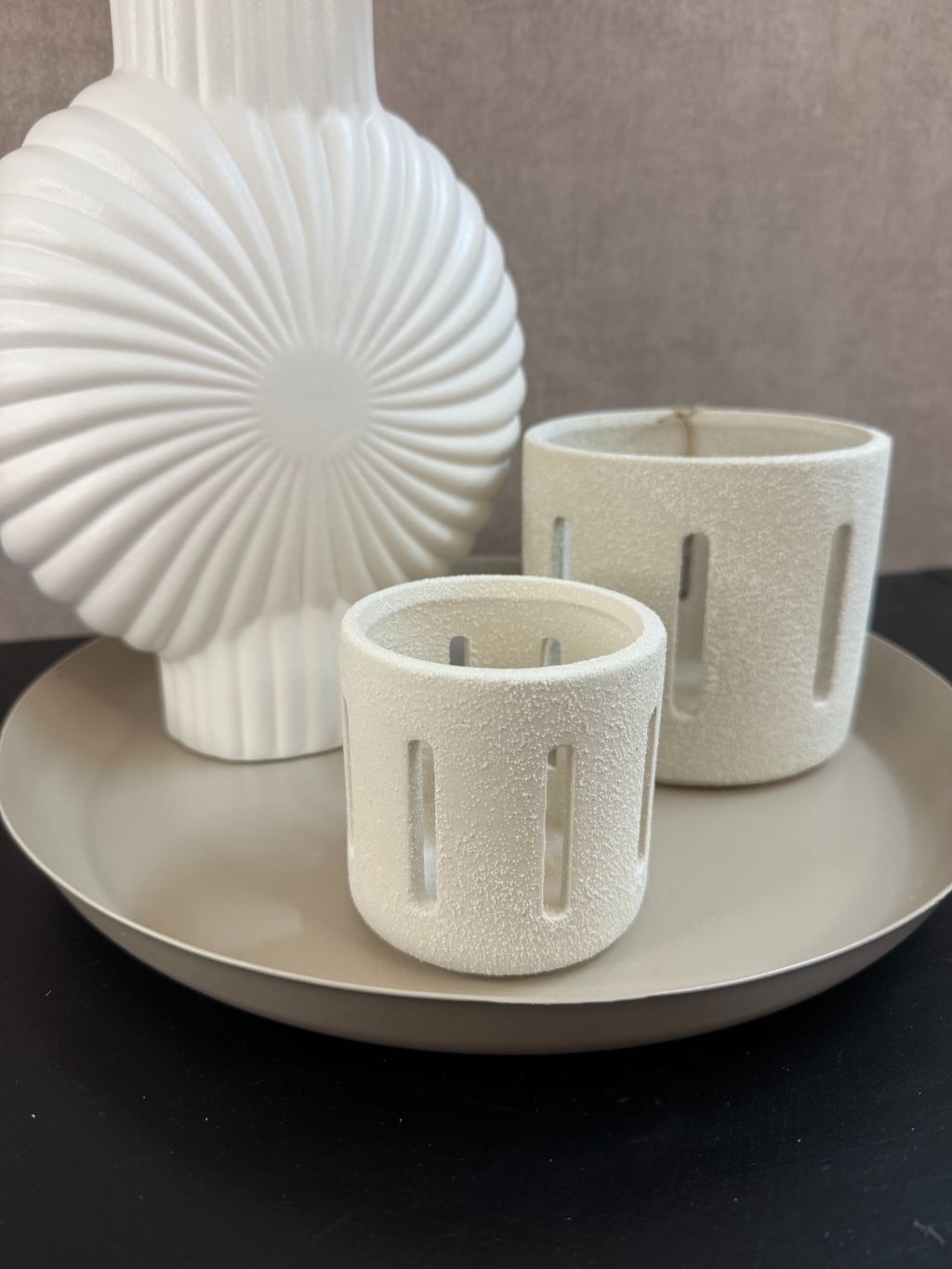 Tafeldecoratieset met witte vaas, zandkleurig dienblad, twee waxinelichthouders en kunsttakken met perzikroze en witte bloesems.