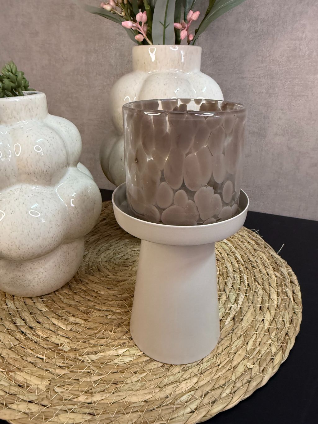 Tafel decoratie set Steffi met beige vazen, roze kunsttak, groene hangplant en waxinelichthouder op een ronde placemat.