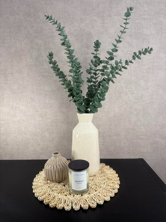 Tafel decoratie set Tessa met raffia placemat, beige vaas met eucalyptus kunsttak en geurkaars Pause Cashmere.