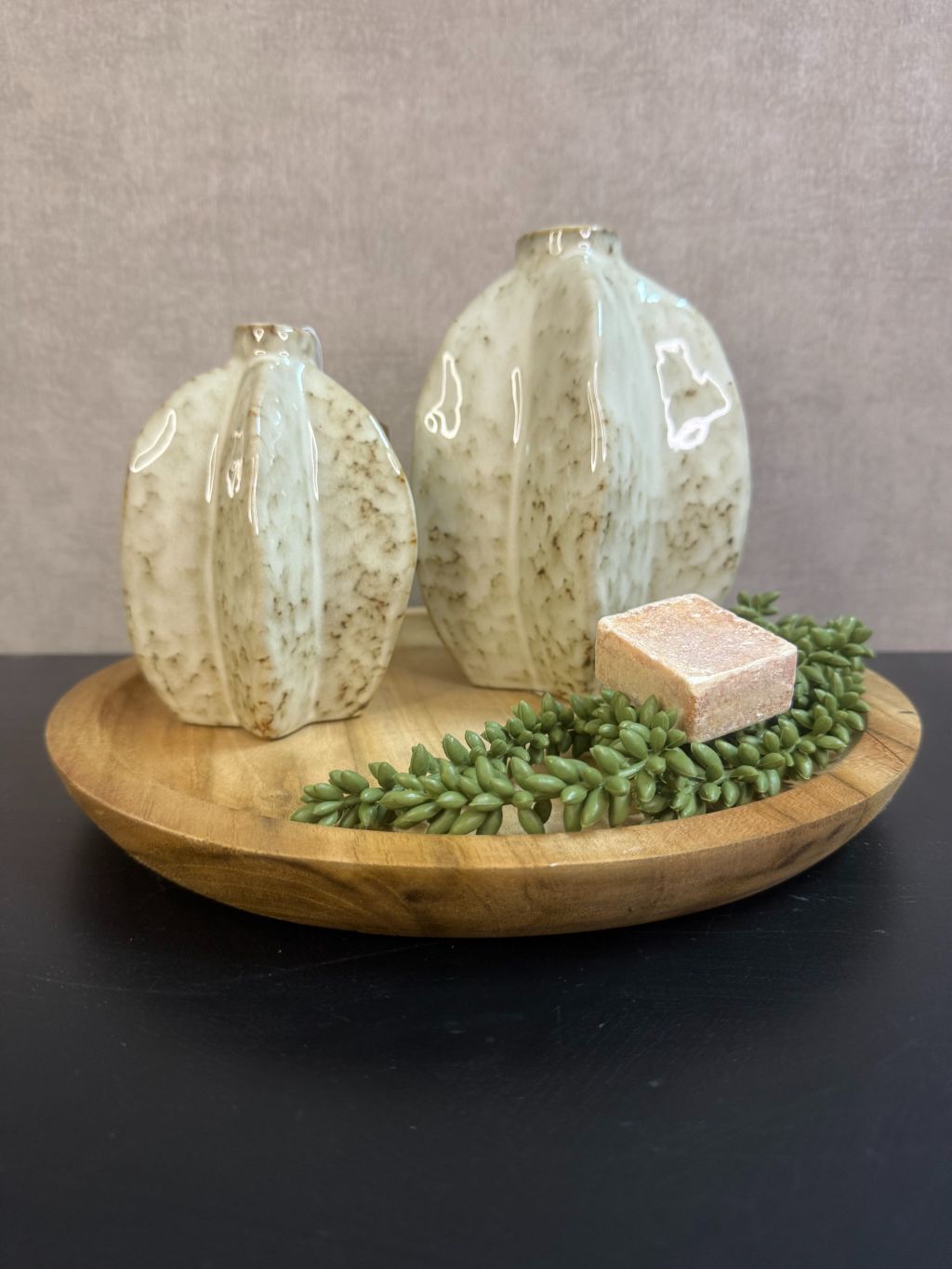 Tafel decoratie set Ellen – houten dienblad met twee beige keramieken vaasjes, groen erwtenplantje en amberblokje in zachte tinten.