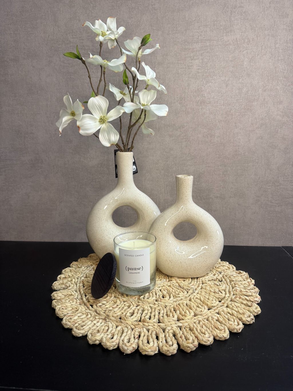 Tafel decoratie set Pause met beige vazen, witte bloementak, gevlochten placemat en geurkaars Pause.