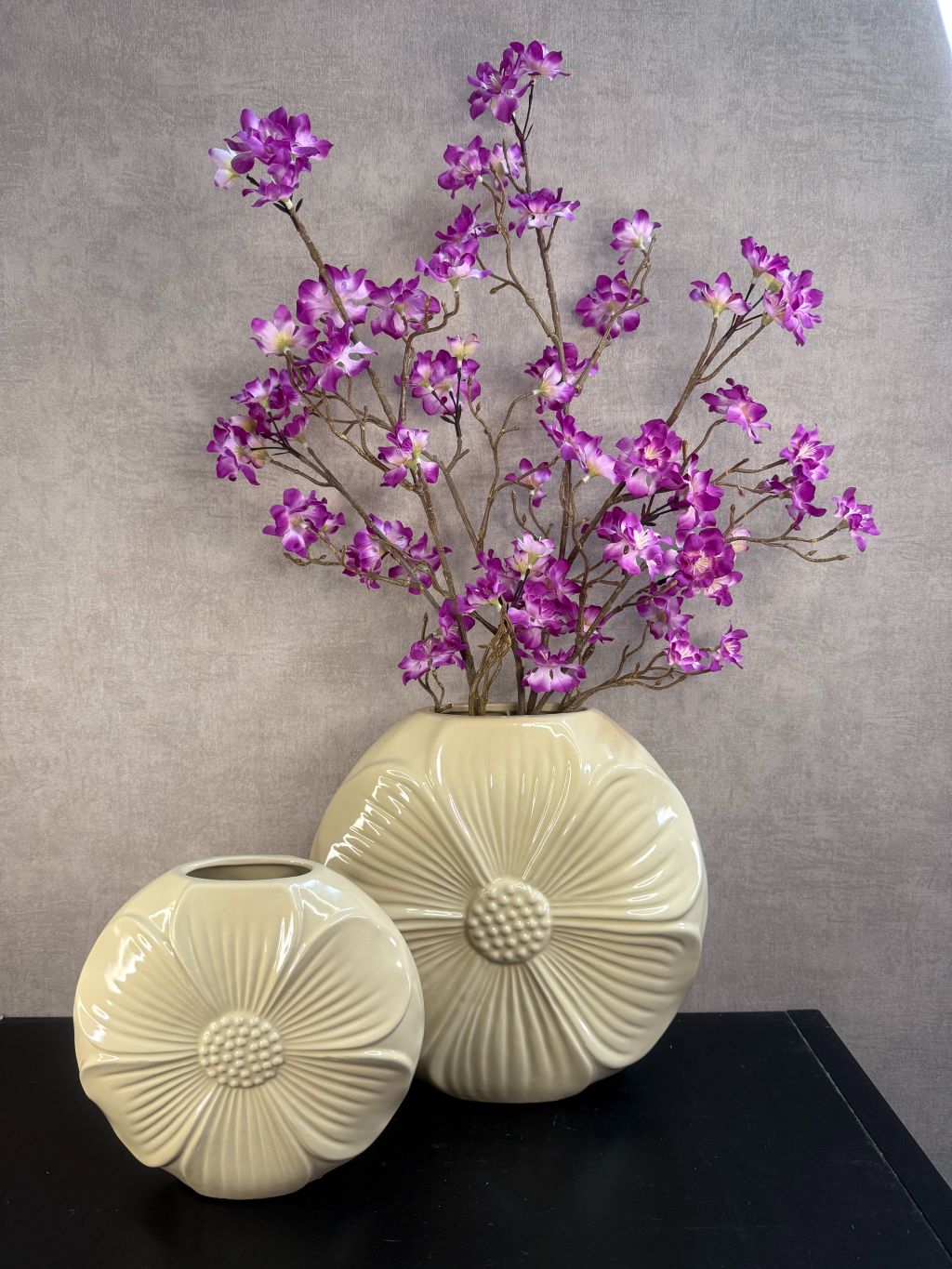 Vensterbank decoratie set met twee crème vazen en paarse kersenbloesem takken, totale hoogte 77 cm.