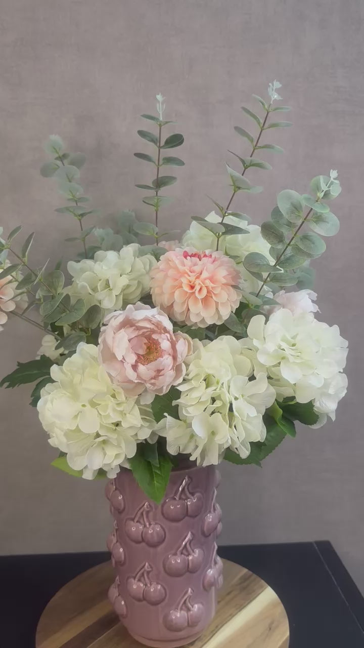 Video van Kunstboeket Amélie – zachte bloemen in ecru, roze en zalmtinten met eucalyptus, in roze vaas met kersenmotief.