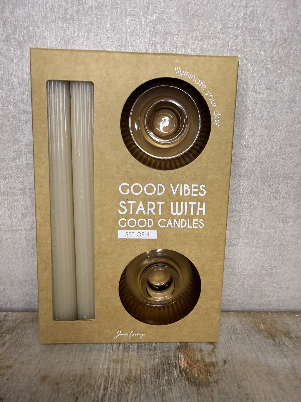 Cadeauset Lumière Amber van JENS Living met twee glazen kandelaars en twee beige dinerkaarsen.