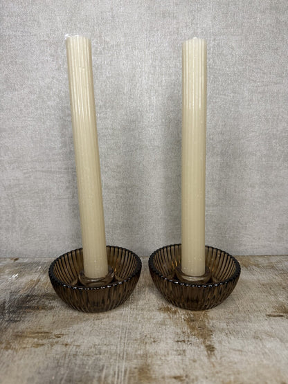Cadeauset Lumière Amber van JENS Living met twee glazen kandelaars en twee beige dinerkaarsen.