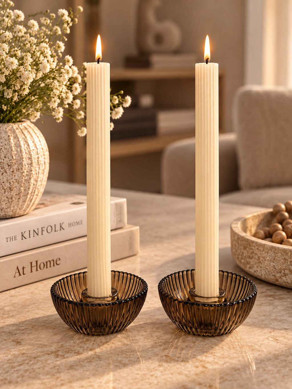 Cadeauset Lumière Amber van JENS Living met twee glazen kandelaars en twee beige dinerkaarsen.