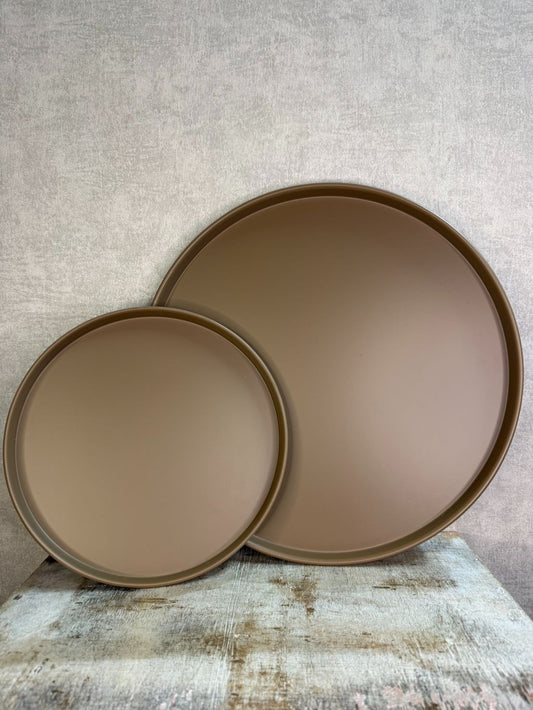 Rond metalen dienblad Coaster in bruine kleur, afgebeeld in twee formaten op een houten ondergrond tegen een neutrale achtergrond.