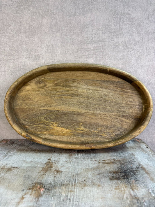 Ovaal houten dienblad met opstaande rand op een houten ondergrond.