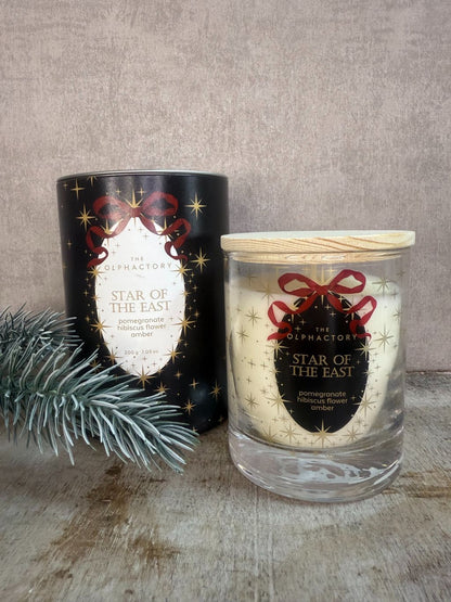 Geurkaars The Olphactory Star of the East met etiket “pomegranate • hibiscus flower • amber” in luxe zwarte verpakking met gouden sterren.