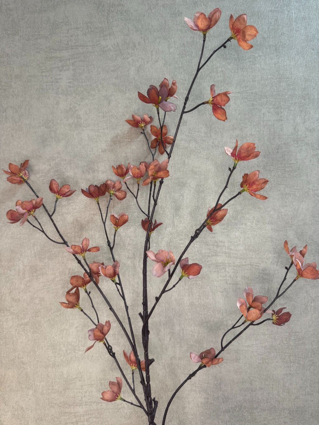 Kunstbloem Bloesem bruin – lange decoratieve tak met kleine bruine bloesemblaadjes tegen een neutrale achtergrond.