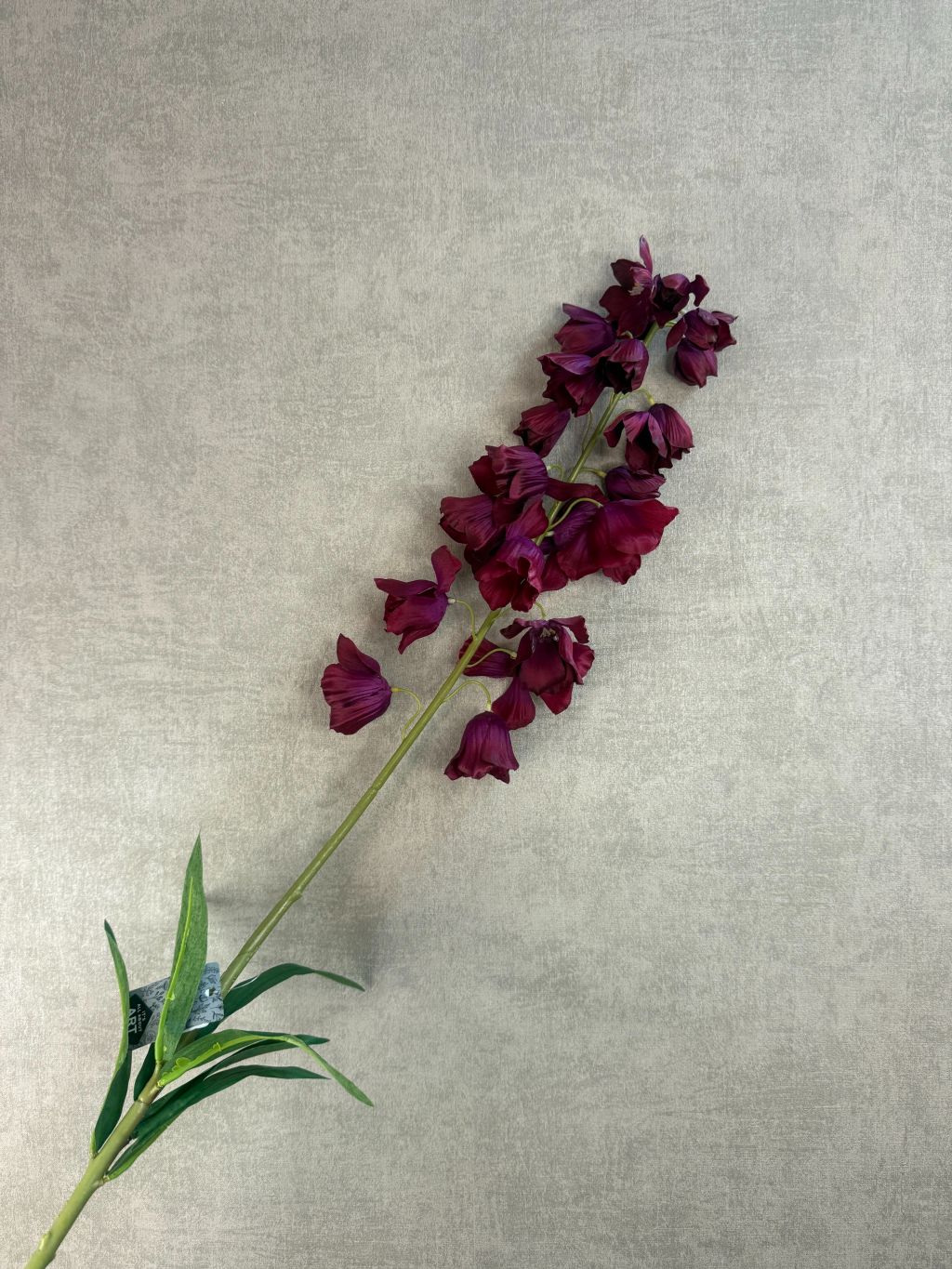 Kunstbloem Campanula in bordeaux rood met belvormige bloemen en lange steel van 92 cm op een grijze achtergrond