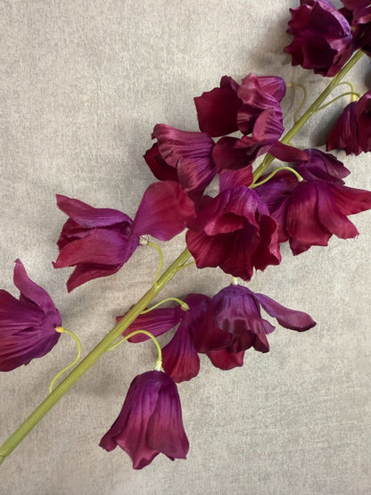 Kunstbloem Campanula in bordeaux rood met belvormige bloemen en lange steel van 92 cm op een grijze achtergrond