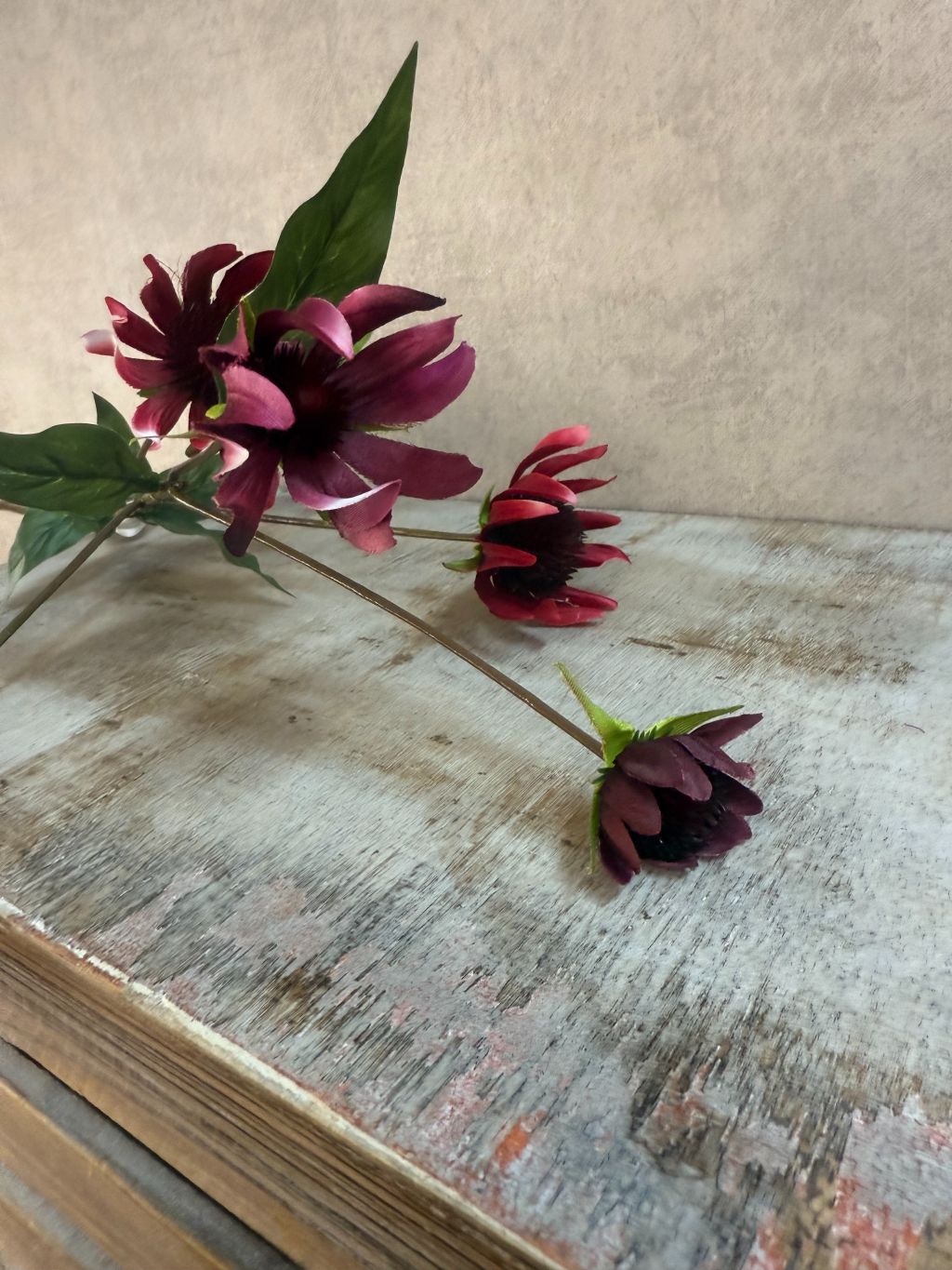 Rode kunstbloem Echinacea (zonnehoed) van 73 cm met realistische details op een houten kist.