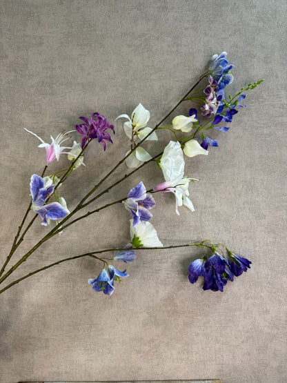 Extra lange kunstbloem met gemengde bloemen in wit, blauw en paars, liggend op een neutrale achtergrond.