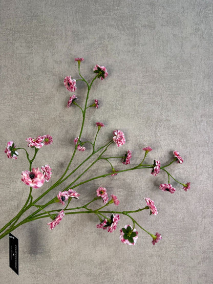 Kunstbloem mini roos in roze kleur met meerdere kleine bloemetjes aan een lange groene steel, gefotografeerd tegen een neutrale achtergrond.