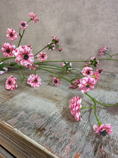 Kunstbloem mini roos in roze kleur met meerdere kleine bloemetjes aan een lange groene steel, gefotografeerd tegen een neutrale achtergrond.