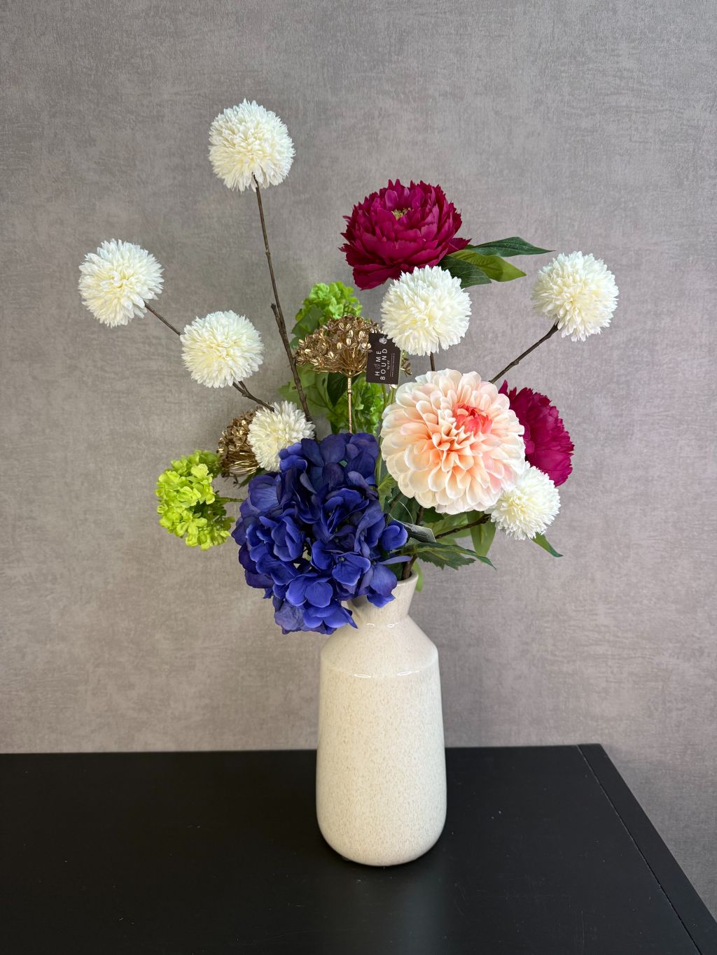 Kunstboeket Liz met bontgekleurde kunstbloemen in een lichte vaas, kleurrijk en speels geschikt als blikvanger.