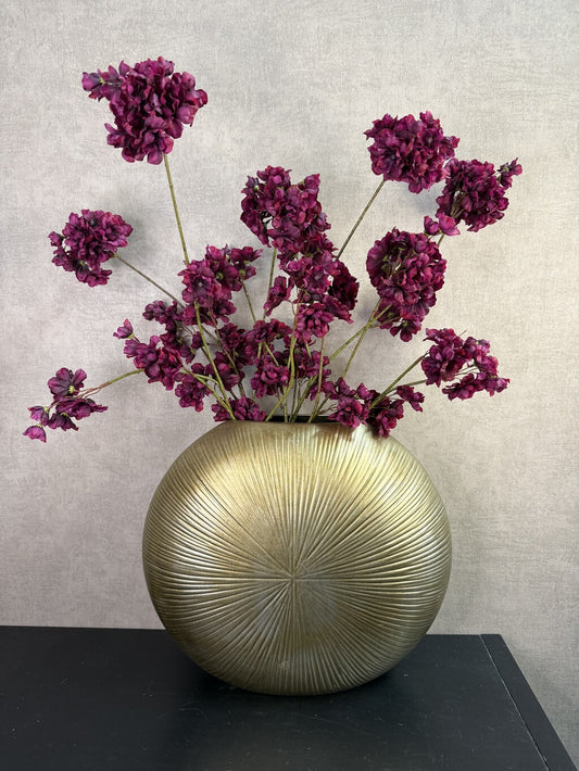 Kunstboeket Prunus in aubergine kleur in een grote ronde vaas met reliëf.
