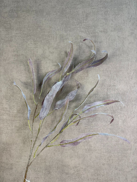 Paarse kunsttak eucalyptus met slanke bladeren en subtiele glitter tegen een neutrale achtergrond.