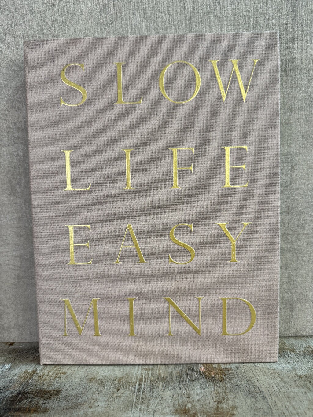 Beige opbergboek van Homebound met goudkleurige tekst Slow Life Easy Mind en een bruin opbergvak aan de binnenzijde.