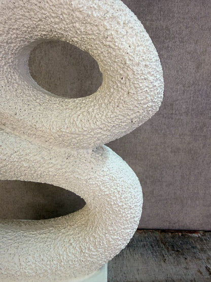 Beige abstract ornament met organische vormen op een rechthoekige voet.