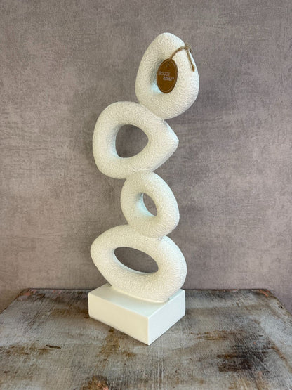 Beige abstract ornament met organische vormen op een rechthoekige voet.