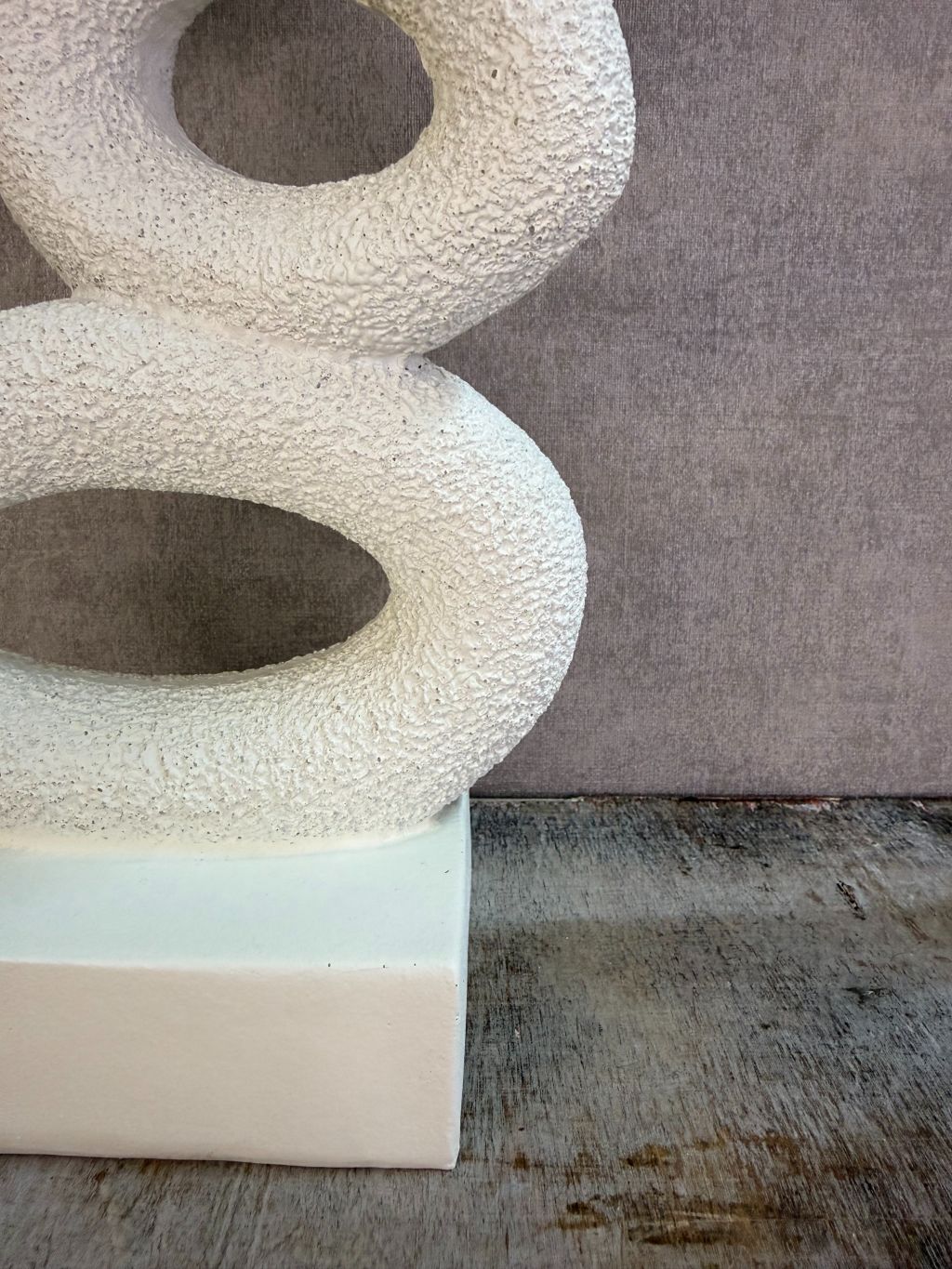 Beige abstract ornament met organische vormen op een rechthoekige voet.