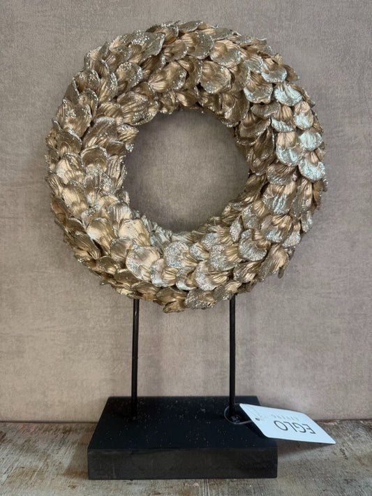 Ornament Krans glitter champagne – ronde decoratie met glanzende bladeren op zwarte standaard van Eglo Living.