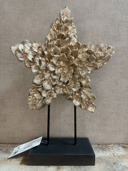 Ornament Ster glitter champagne – decoratieve ster met glanzende bloemvormige blaadjes op zwarte standaard.