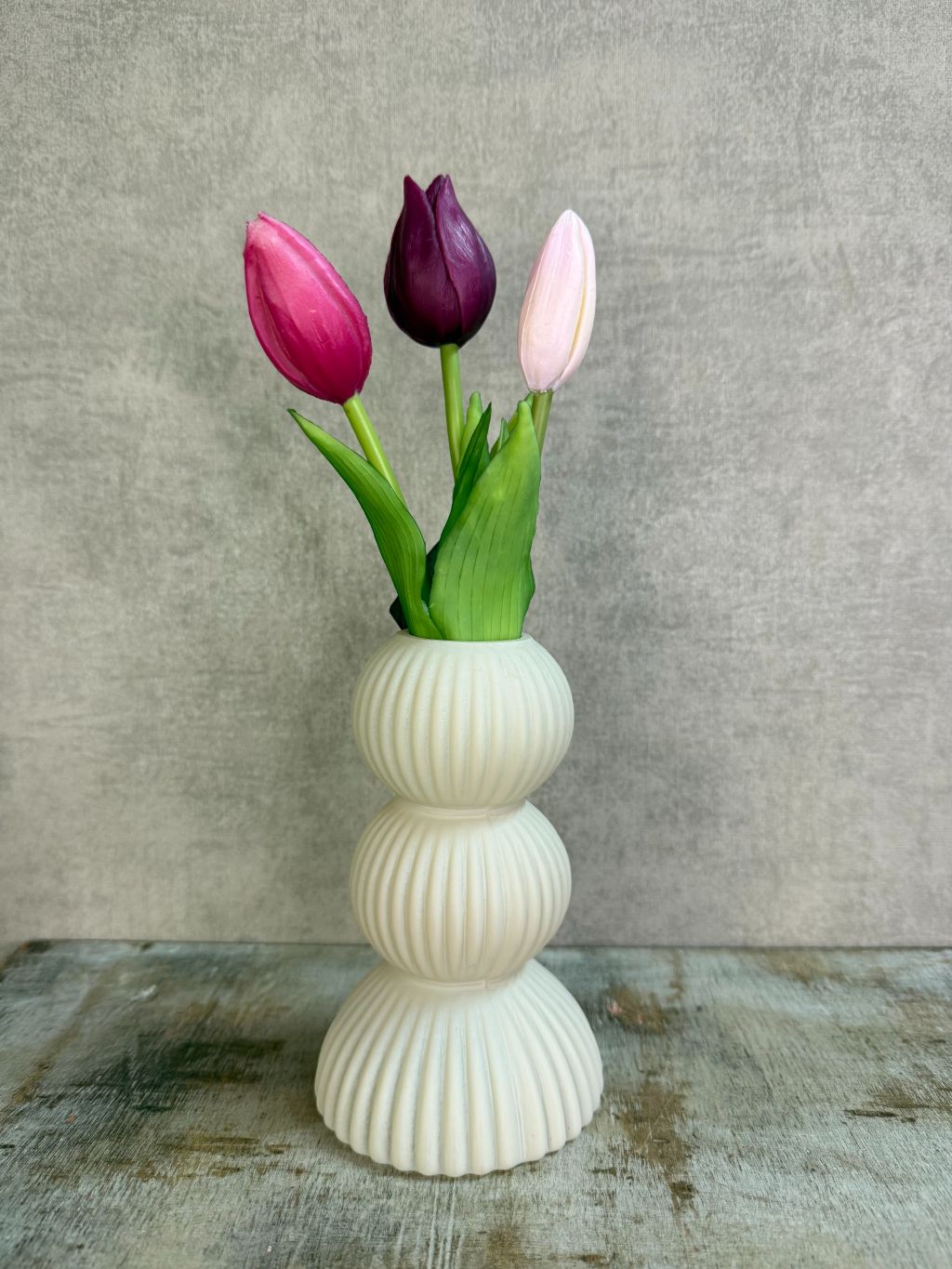 Bos real touch tulpen in paars- en rozetinten met groene bladeren, geschikt voor een kleine vaas.