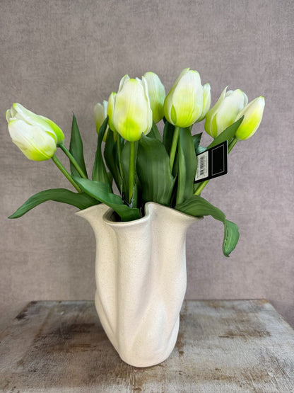 Bos real touch tulpen in wit met groene bladeren, samengebonden en geplaatst tegen een neutrale achtergrond.