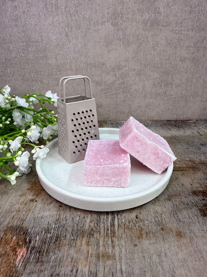 Wit keramieken schaaltje met  accessoires op een houten ondergrond tegen een neutrale achtergrond.