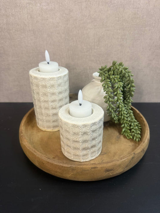 Rond houten dienblad met twee beige waxinelichthouders met LED-lichtjes, klein vaasje en groen kunsthangplantje, als stijlvolle tafel- of vensterbankdecoratie.