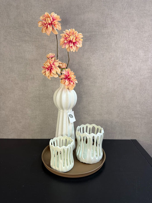 Tafel decoratie set met zalmkleurige dahlia’s, crème accessoires en bruin rond dienblad, stijlvol gepresenteerd op een tafel.